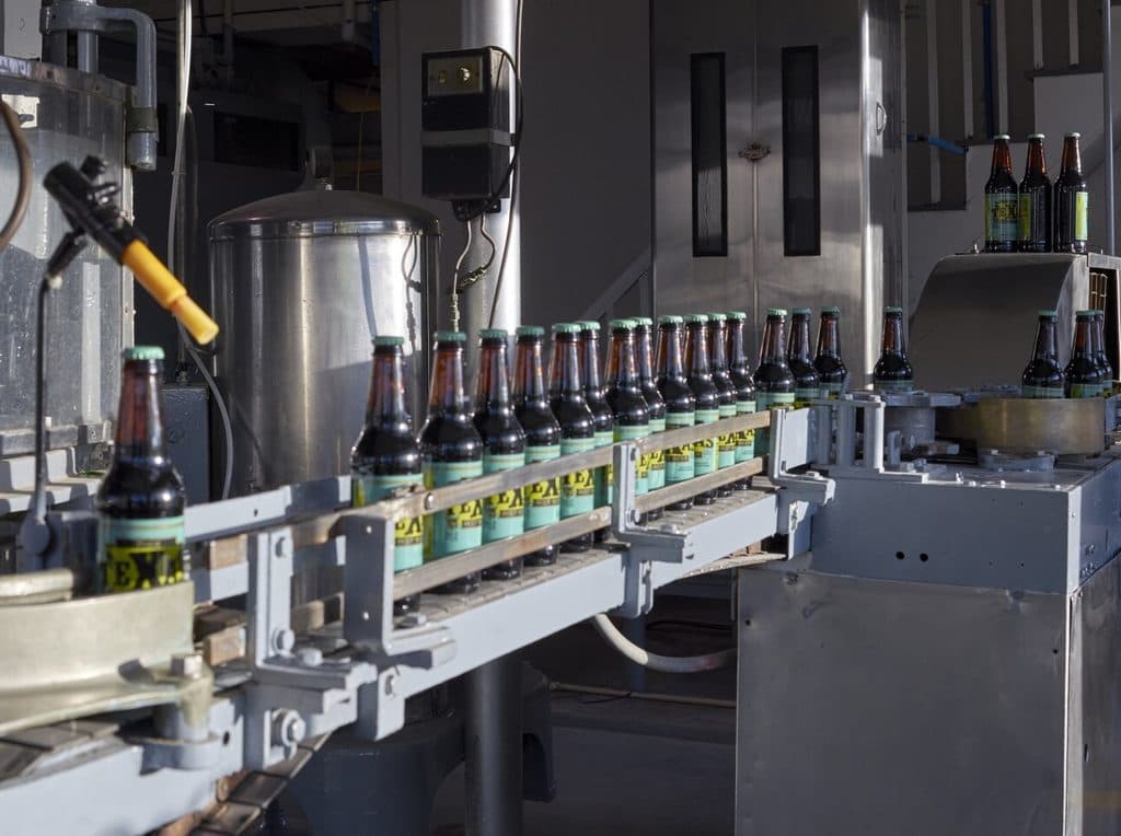 Botellas etiquetadas sobre la cinta de una línea de envasado
